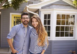 Excited Couple Standing Outside New Home